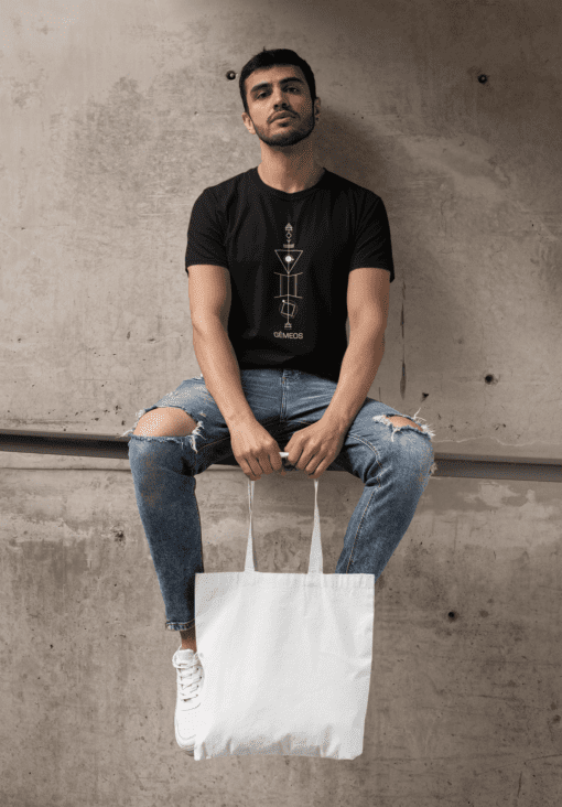 t shirt mockup of a bearded man with a tote bag sitting on a concrete structure 29412 - Varegue