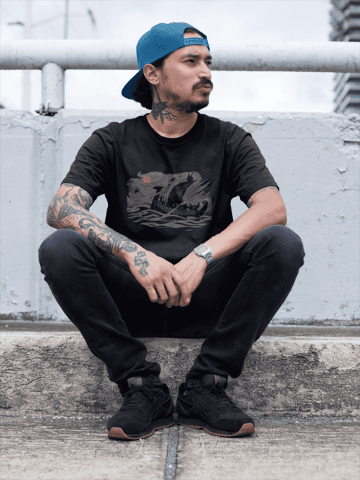 mockup of a tattooed hispanic man wearing a round neck tee while sitting down on a sidewalk a17084 - Varegue